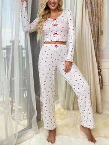 Close-up of white pajama set featuring red heart patterns and delicate bow details