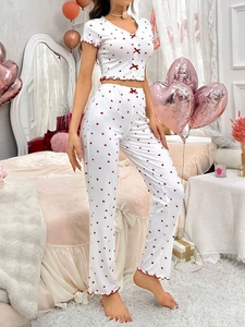Close-up of heart print pajamas featuring red ribbon bows and wavy ruffle edges