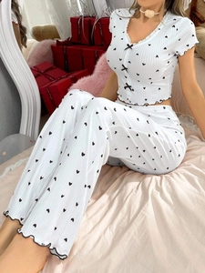 Close-up of ribbed fabric with heart prints, ruffle edges, and a black bow detail