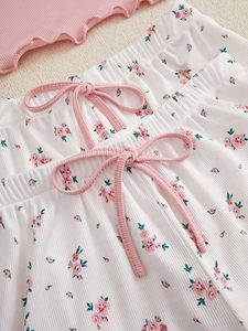 Detailed view of floral ribbed fabric shorts with pink bow and ruffled hems