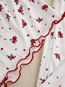 Detail of floral ribbed fabric with red lettuce edge trim on three-piece pajama set