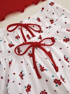 Detail of ribbed floral loungewear featuring red lettuce trim and bow accents