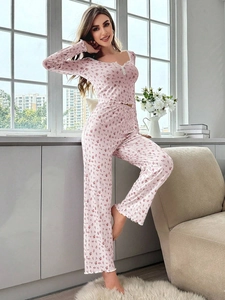 Détail d'un pyjama rose à fleurs avec col en V en dentelle et bordures à volants