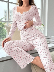 Détail d'un pyjama à fleurs roses avec col en V boutonné et bordures en dentelle blanche