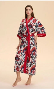 Détail d'un peignoir kimono en satin fleuri avec col en V rouge et ceinture assortie