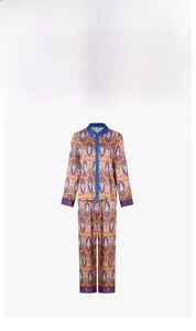 Detail of vibrant ikat pattern satin pajama set with contrast blue piping and red buttons