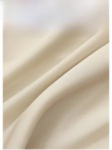 Close-up of beige satin sleepwear fabric material showing soft texture and drape