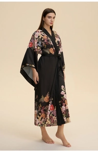 Vue détaillée du peignoir long en satin noir avec motifs floraux et ceinture à la taille