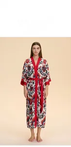 Détail d'un peignoir en satin à fleurs vintage avec bordure rouge et motifs ethniques