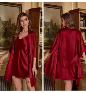 Detail of burgundy satin pajama set featuring a deep V-neck slip dress and matching silk robe