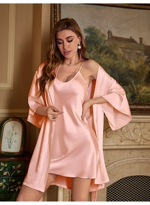 Macro shot of silk texture on pink V-neck nightgown and matching satin robe set