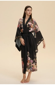 Détail d'un long peignoir en satin noir pour femme avec d'élégants motifs floraux roses