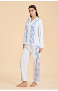 Detail of floral patterns on white satin pajama set with blue vine prints and textures