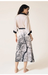 Detail of satin floral robe featuring black branch print and elegant contrast piping