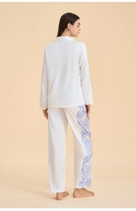 Rear view of white satin pajama set featuring long sleeves and flowing straight-leg trousers
