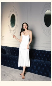 Detailed view of elegant white satin camisole dress with thin straps and glossy finish