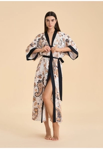 Détail du peignoir en satin blanc à motif paisley avec bordures noires contrastées