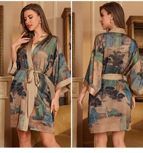 Detail of satin kimono robe featuring traditional landscape prints and gold trim