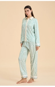 Close-up of mint green pajama set featuring intricate white mandala patterns and decorative borders