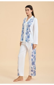 Close-up of white satin pajama set featuring blue floral paisley patterns and silky texture
