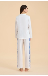 Detail view of white satin pajama set with blue paisley print on sleeves and pants