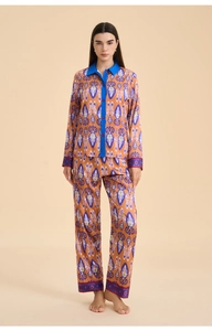 Close-up of ethnic ikat print satin pajama set with contrast collar and red buttons