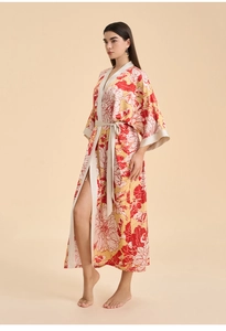 Détail d'un peignoir en satin à fleurs avec motif rouge et jaune et fente latérale