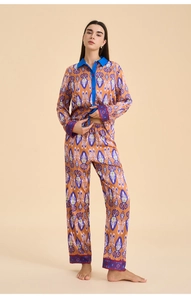 Detailed view of women's orange ethnic ikat print satin pajama set with blue collar trim