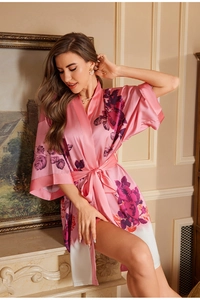 Detail of luxurious pink satin bathrobe with elegant floral rose patterns and belted waist