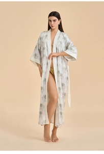 Détail du peignoir en satin avec motifs d'abeilles dorées et tissu en soie blanche élégant
