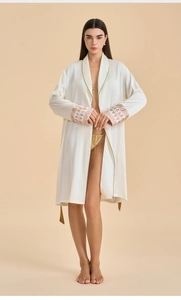 Close-up of red and gold floral embroidery on white satin robe sleeves and cuffs