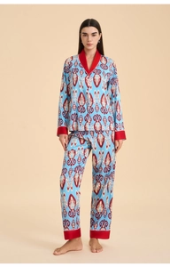 Dettaglio del pigiama in raso con motivo Ikat blu esotico e piping rosso a contrasto