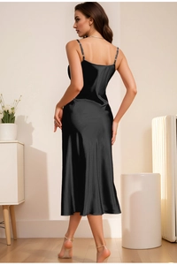 Detail of black satin slip dress showing elegant backless design and thin straps