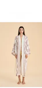 Close-up of bohemian floral print and soft satin texture on long white kimono robe