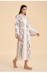 Detail of white floral satin robe showing vintage botanical print and smooth silk texture