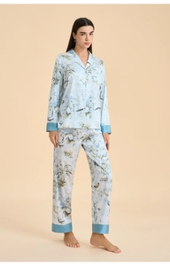 Detail of light blue floral pajama set with bird print and elegant dark blue piping