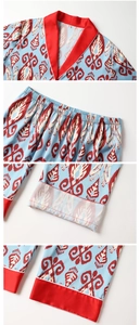 Dettaglio del pigiama in raso con stampa ikat, profili rossi ed elastico in vita