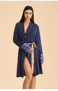 Detail of navy satin robe with golden piping, ribbon waist tie and ethnic totem cuffs