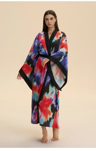 Detail of vibrant abstract print satin robe featuring black trim and flowing long sleeves