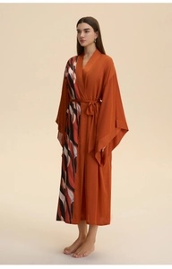 Detail of rust red satin robe featuring abstract flame print and elegant kimono sleeves