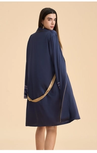 Detail of dark blue satin robe showing gold trim and patterned cuffs on a back view