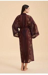 Back view of a sheer burgundy long robe featuring gold leaf patterns and wide sleeves
