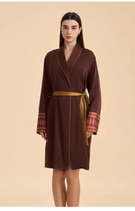 Detail of satin robe with golden piping and intricate brocade floral patterns on cuffs