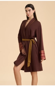 Detail of satin robe with golden piping, ethnic cuff patterns and matching waist belt
