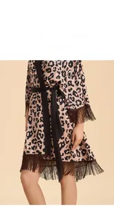 Vue détaillée du peignoir en satin imprimé léopard avec poignets à franges et ceinture noire