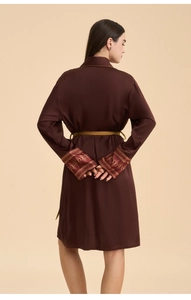 Detail of satin robe sleeve with ethnic jacquard trim and golden waist tie detail