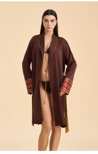 Detail of satin robe sleeve with intricate gold floral embroidery and golden piping