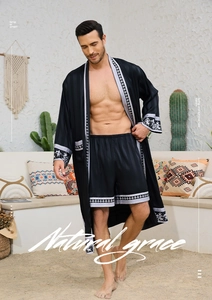 Detailed view of black satin men's robe set with ethnic jacquard trim in a desert setting