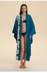 Detail of dark blue satin robe featuring orange leaf prints and elegant wide cuffs