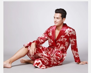 Detail view of red silk satin men's robe with golden dragon pattern and belted waist